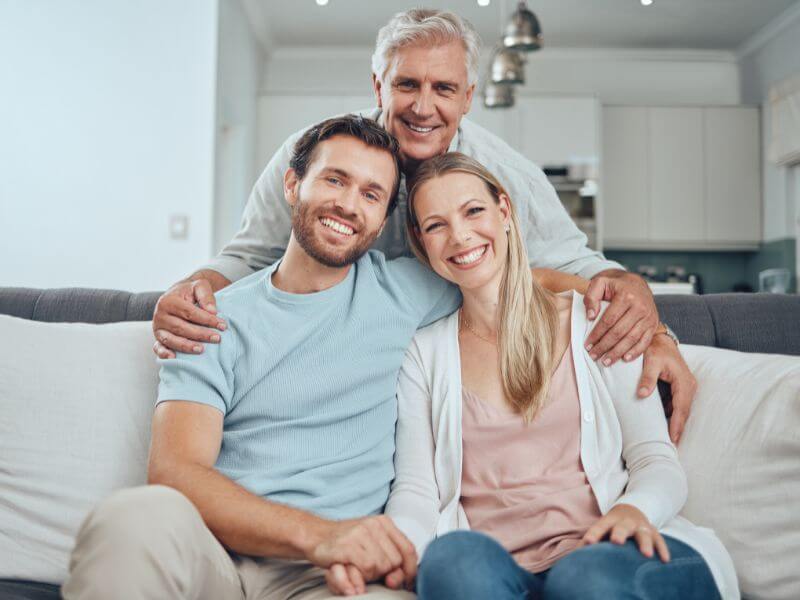 A-cheerful-elderly-man-stands-behind-a-seated-couple-1 A-cheerful-elderly-man-stands-behind-a-seated-couple-1